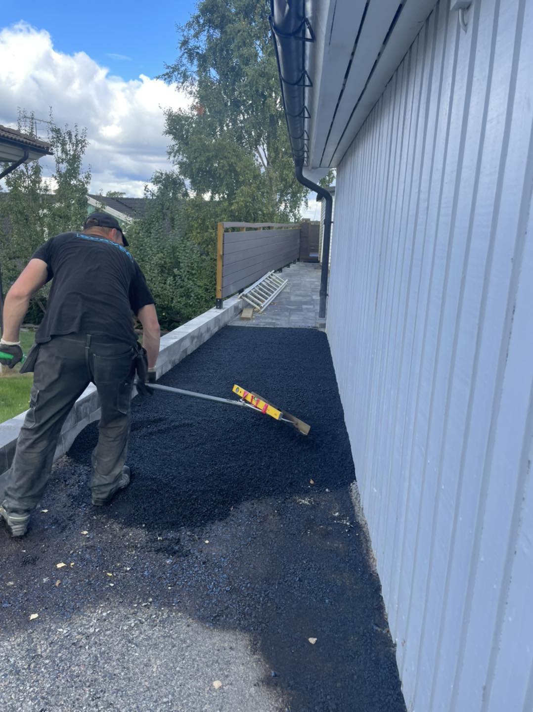 Hantverkare utför markarbete mot husgrund